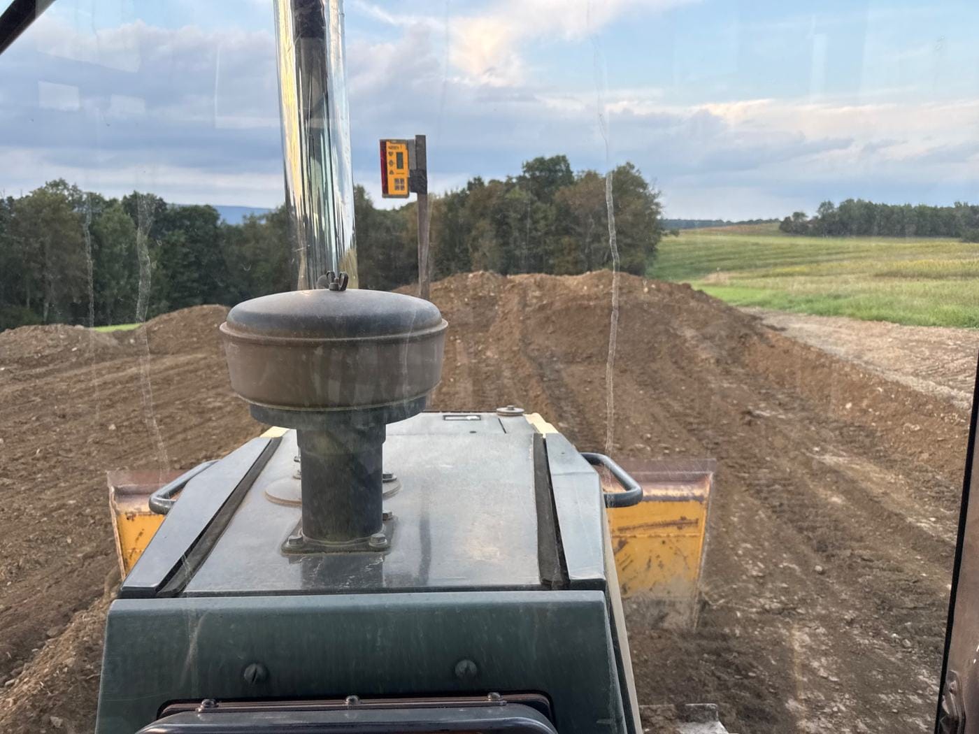 A fresh cut across open ground, seen from the dozer.