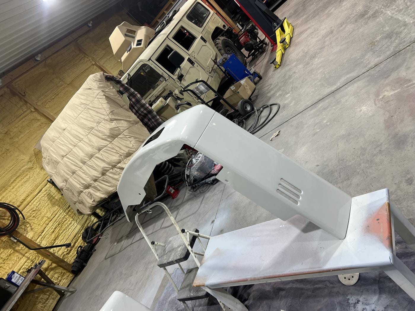 A fender in primer set up on a stand in the shop.
